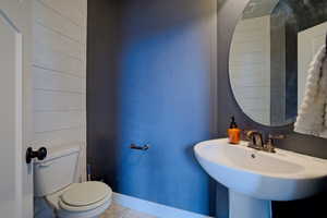 Bathroom featuring tile patterned floors, toilet, and baseboards