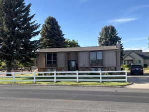 View of front facade featuring a fenced front yard and stone siding