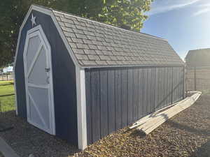View of shed featuring fence