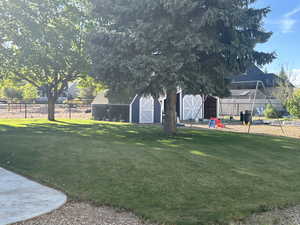 View of yard featuring fence, an outbuilding, and a barn