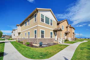 Exterior space featuring a yard, stone siding, and stucco siding