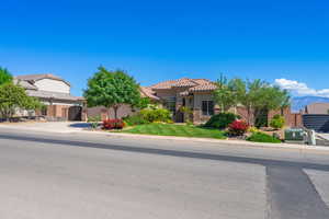 Obstructed view of property featuring stucco siding and a tile roof