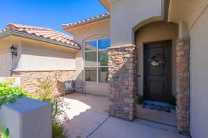 Entrance to property featuring stone siding and stucco siding
