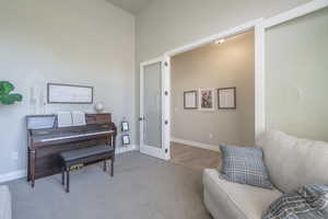 Living area featuring carpet flooring, french doors, and baseboards