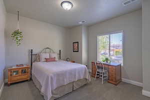 Bedroom featuring light carpet, baseboards, and visible vents