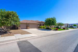 Mediterranean / spanish-style house featuring an attached garage, stone siding, driveway, stucco siding, and a tiled roof