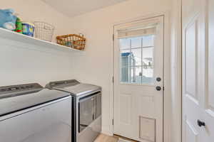 Laundry room featuring laundry area, washer and clothes dryer with storage and pantry