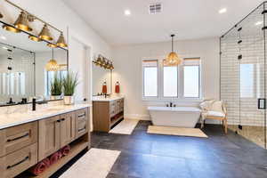 Primary Bathroom featuring separate dual vanities, soaker tub, and enclosed double-headed shower