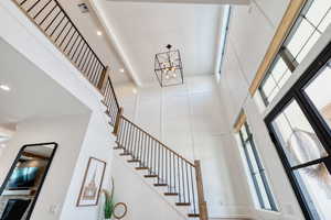 Entryway stairway leading to the upstairs, and towering vaulted ceilings