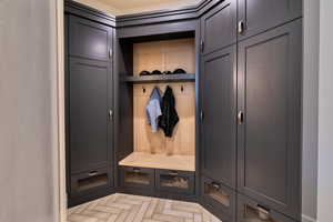 Mudroom with custom storage cabinetry and built-in hooks