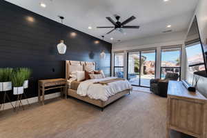 Primary Bedroom featuring a wall of windows and sliding glass door access to an outside covered patio