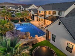 Resort-style backyard with outdoor lighting and maintenance-free turf