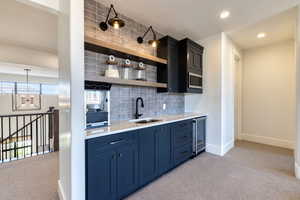 Wet Bar featuring sink, microwave, and beverage cooler