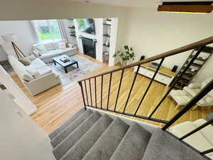 Stairway with a fireplace and wood finished floors
