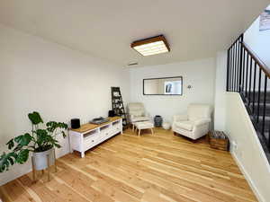Sitting room featuring stairs and light wood-type flooring