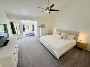 Bedroom with carpet flooring, baseboards, lofted ceiling, and ceiling fan