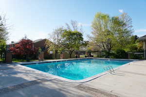 View of swimming pool featuring a patio area, fence, and a fenced in pool