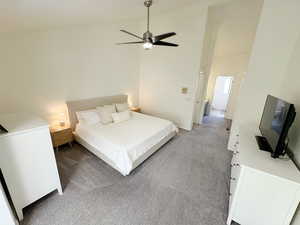 Bedroom with lofted ceiling, a ceiling fan, and light colored carpet