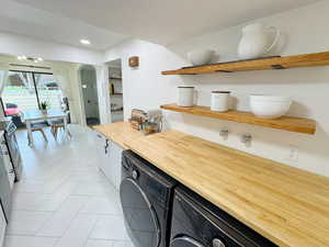 Bar featuring independent washer and dryer, arched walkways, and recessed lighting