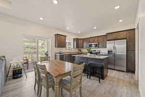 Dining area with recessed lighting and light wood-type flooring