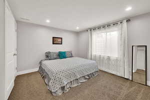 Bedroom with carpet floors, baseboards, visible vents, and recessed lighting