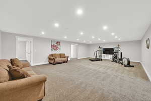 Carpeted living area featuring baseboards and recessed lighting