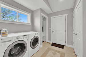 Clothes washing area with baseboards, washer and dryer, visible vents, light tile patterned flooring, and laundry area