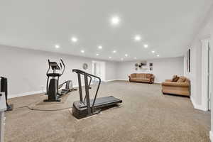 Exercise area featuring carpet floors, baseboards, and recessed lighting