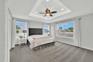 Bedroom featuring a raised ceiling, carpet flooring, visible vents, and recessed lighting