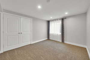 Unfurnished bedroom featuring carpet flooring, baseboards, and recessed lighting