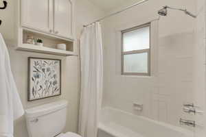 Full bath featuring toilet and shower / bath combo
