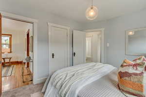 Bedroom with a closet, wood finished floors, and baseboards