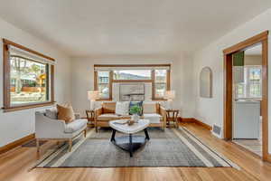 Sitting room featuring visible vents, light wood-style flooring, and baseboards