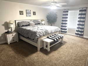 Bedroom featuring baseboards, carpet flooring, and ceiling fan