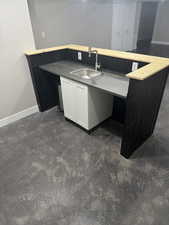 Kitchen featuring white cabinetry, baseboards, and a sink