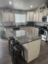 Kitchen with a sink, recessed lighting, decorative backsplash, and appliances with stainless steel finishes