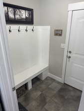 Mudroom featuring baseboards and stone finish flooring
