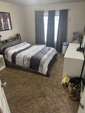 Bedroom featuring dark carpet
