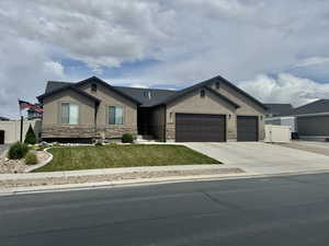Ranch-style home with fence, a garage, stucco siding, and stone siding