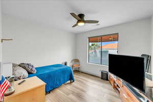Bedroom with light wood-style flooring, baseboards, a ceiling fan, and visible vents