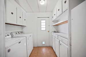 Laundry room featuring cabinet space, independent washer and dryer, and a textured ceiling