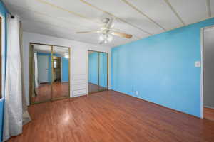 Unfurnished bedroom featuring a closet, visible vents, wood finished floors, and ceiling fan