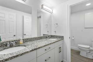 Main bath with double vanity and separate shower/toilet area with door