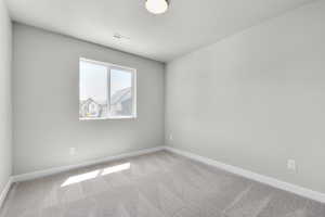Spare room featuring carpet floors and baseboards