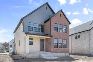 View of front of home with central AC and board and batten siding