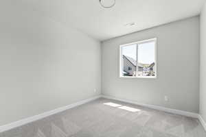 Carpeted spare room with baseboards