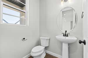 Bathroom with baseboards, toilet, and wood finished floors