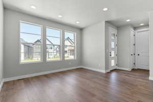 Empty room with wood-type flooring, baseboards, and recessed lighting