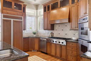 Kitchen with 2 stainless steel sinks, cherry cabinetry, premium cook top and range hood