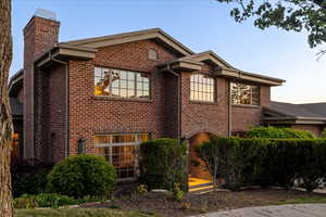 View of home's exterior with a chimney and brick siding